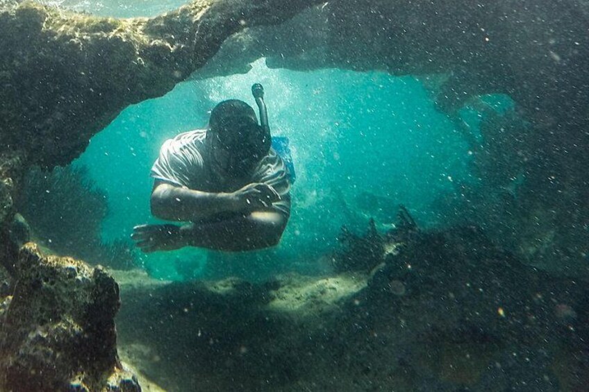A person scuba diving in a clear blue underwater environment. 2