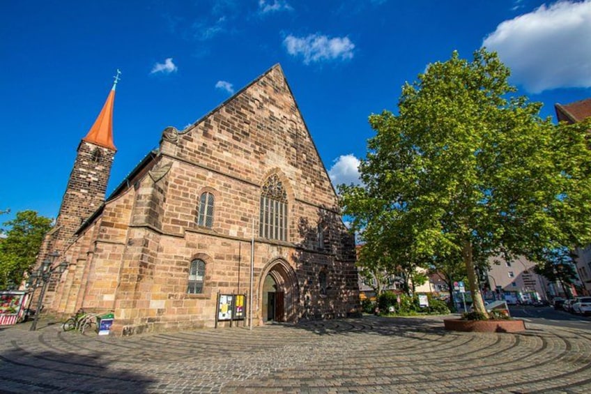 Een historisch kerkgebouw met een opvallende kerktoren en grote ramen. 2