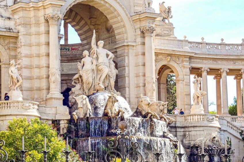 Una fuente clásica con estatuas, un amplio arco y un cartel con texto. 5
