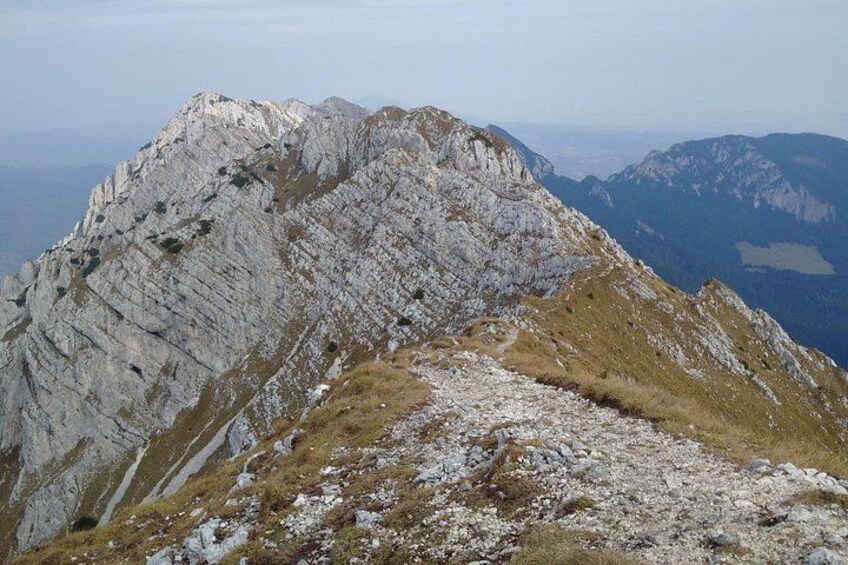 A rugged mountain ridge with rocky terrain and sparse vegetation. 2