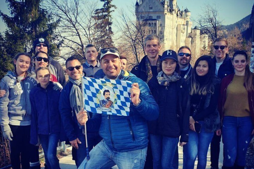 A group of people standing in front of a castle-like structure. 2