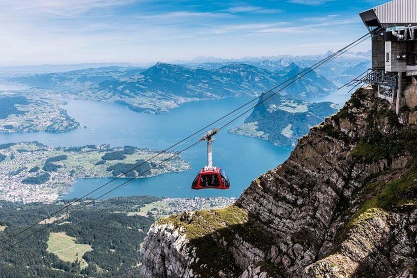 Un teleférico suspendido sobre un paisaje montañoso con un lago en la parte inferior. 1