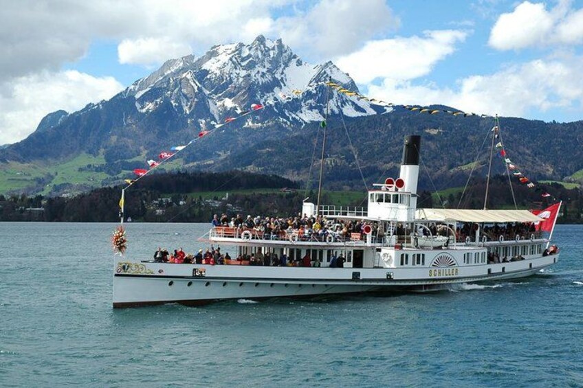 A boat with passengers, a mountainous landscape, and a clear sky. 3
