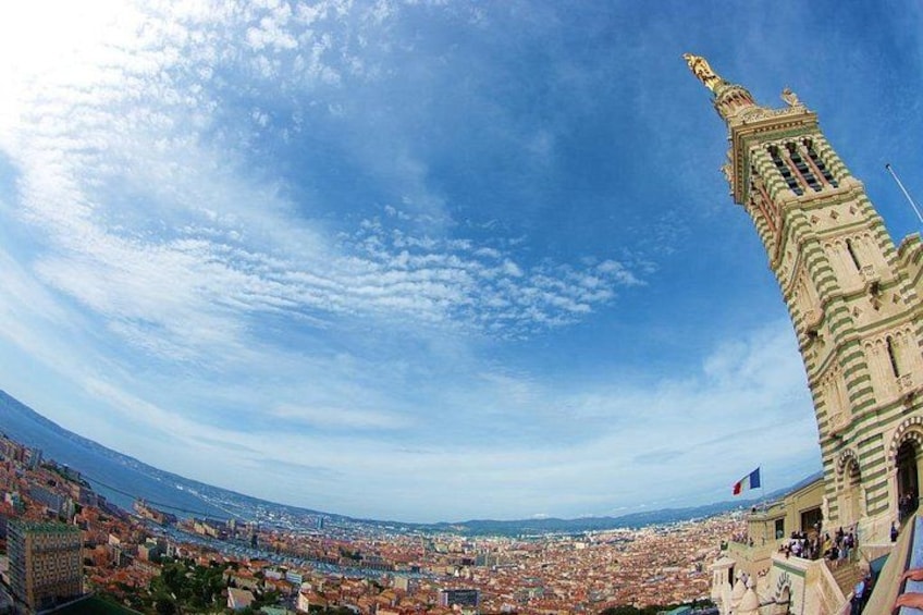 A cityscape with a prominent tower, a clear sky, and a distant coastline. 1