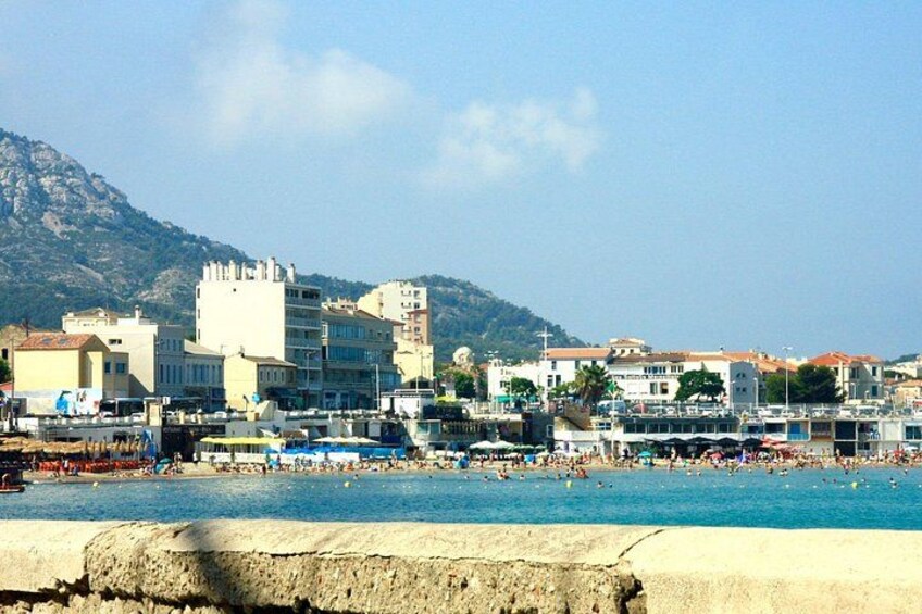 A coastal cityscape with a beach, buildings, and a mountain in the background. 3