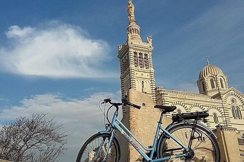 A large building with a tall tower and a dome, a bicycle in the foreground, and a clear sky. 5