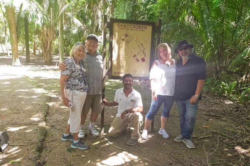 A group of people posing in front of a sign with a map. 2