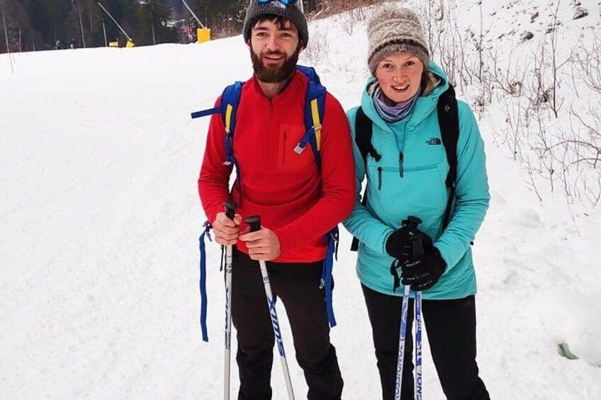 To personer vandrer i et sneklædt landskab med ski stave. 4