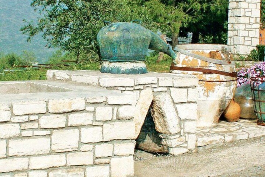 A stone wall with a large green pot and a smaller pot on top. 5