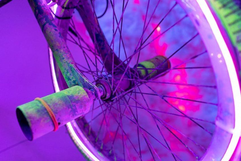 A bicycle wheel with spokes and a green handlebar. 4