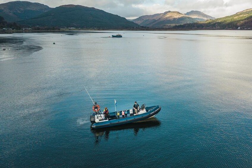 Un petit bateau sur une eau calme, avec des montagnes en arrière-plan. 3