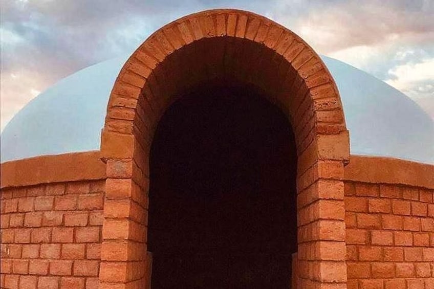 A brick archway with a dome structure above it. 1