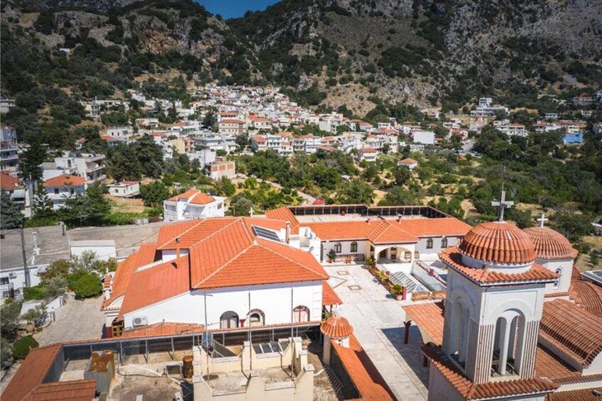A mountainous town with red-roofed buildings, including a church with a dome. 2