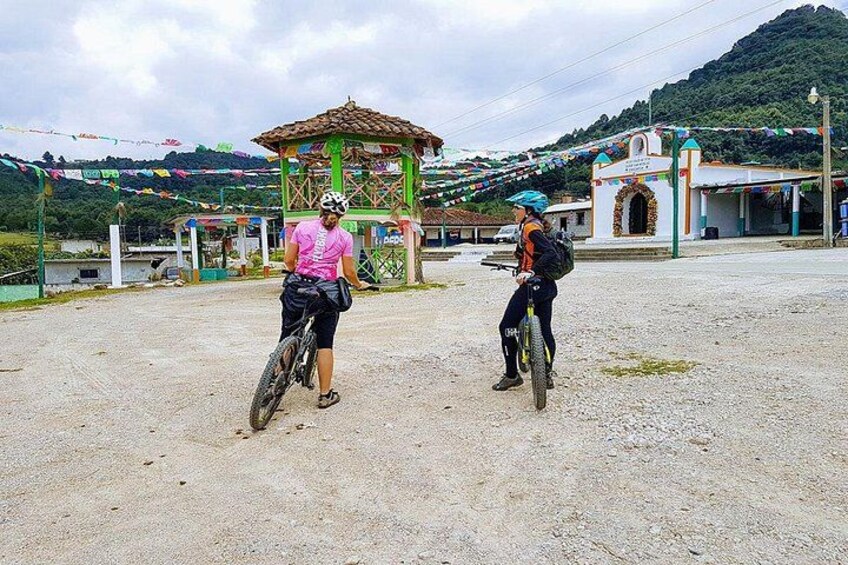 Deux cyclistes sur un chemin de gravier, avec un belvédère et une montagne en arrière-plan. 4
