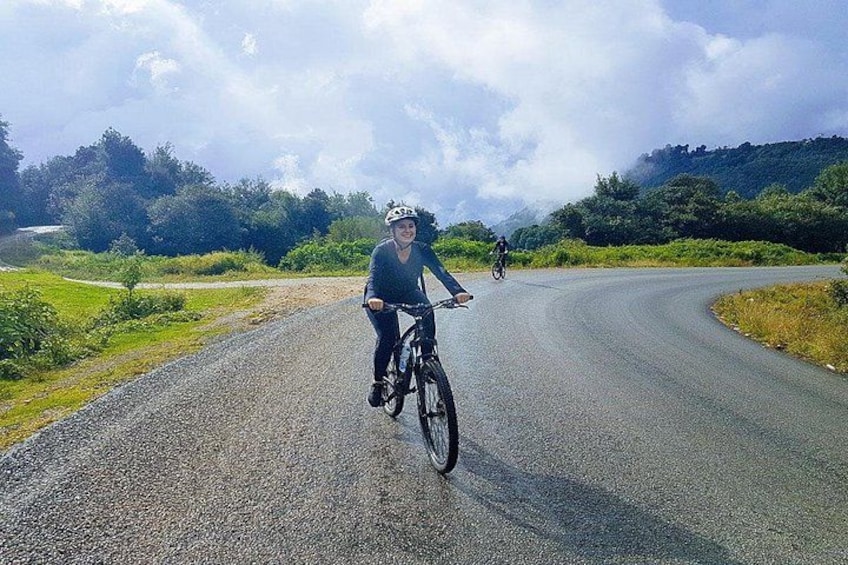 Un cycliste sur une route asphaltée, avec un paysage vallonné en arrière-plan. 3