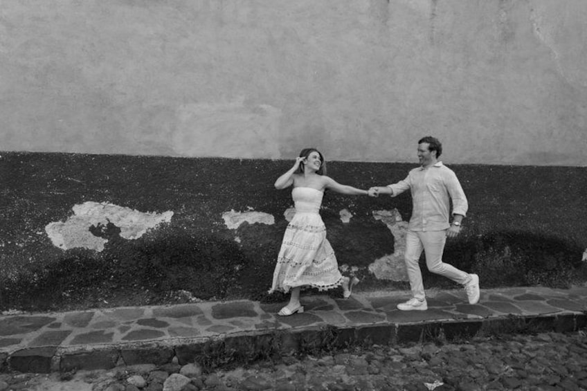 Un uomo e una donna camminano mano nella mano lungo un sentiero in pietra. 3