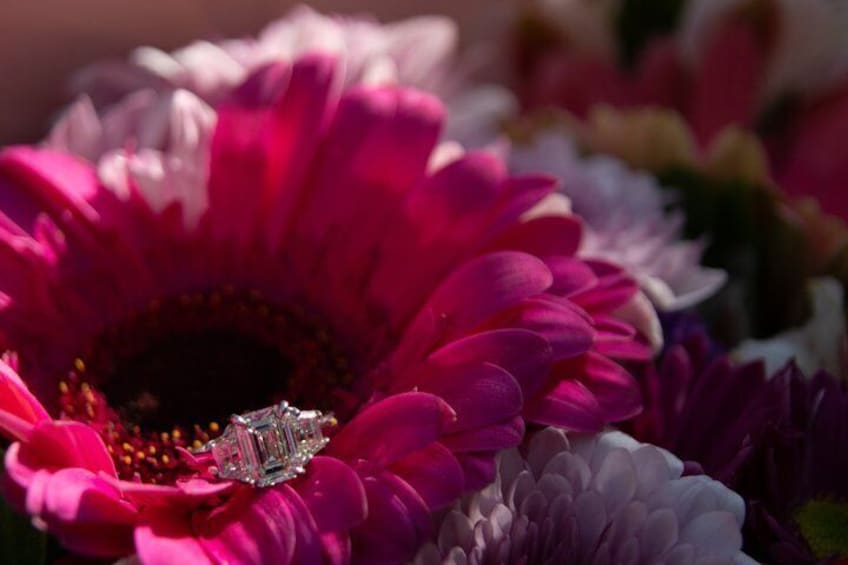 Un primo piano di un fiore rosa con un anello di diamanti. 2
