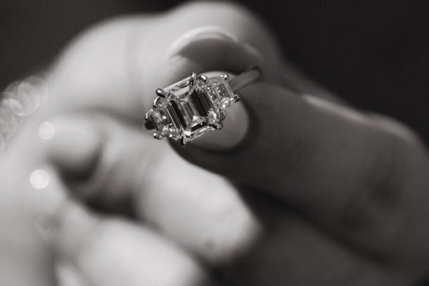Una mano che tiene un anello con una pietra preziosa rettangolare e grande. 5