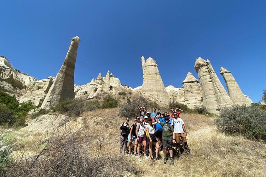 A group of people standing on a hill with distinctive rock formations in the background. 3