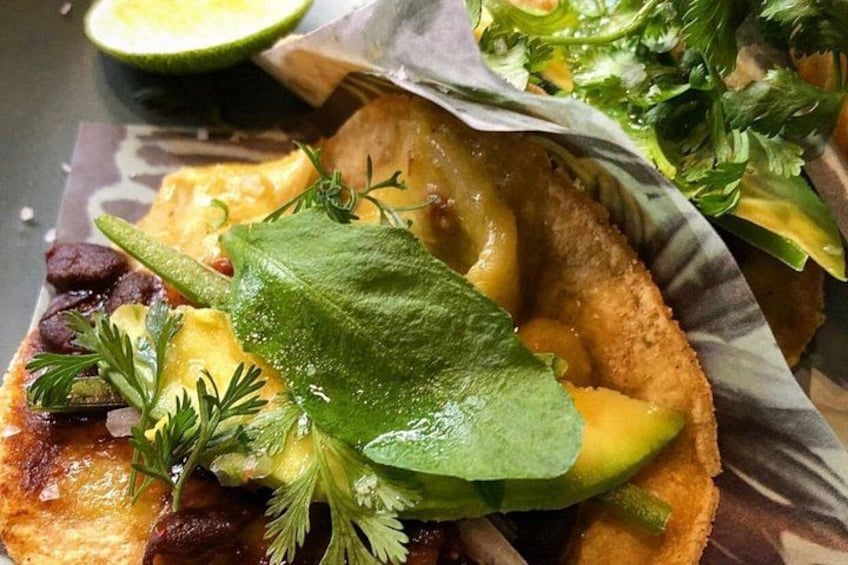 Un plat composé d’avocat, de légumes verts et d’une tranche de citron vert. 2