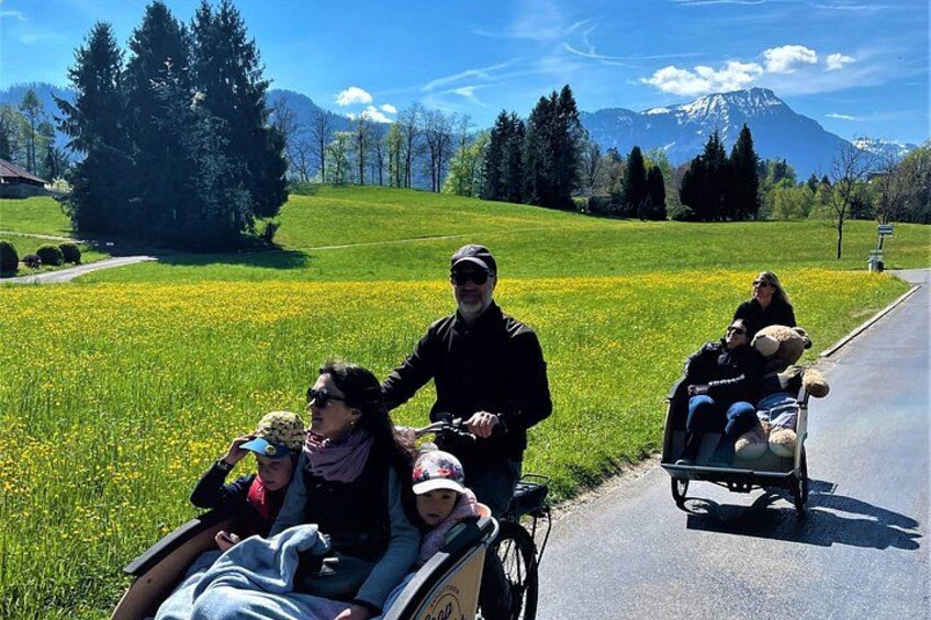 A group of people in a countryside setting with a mountain in the background. 1