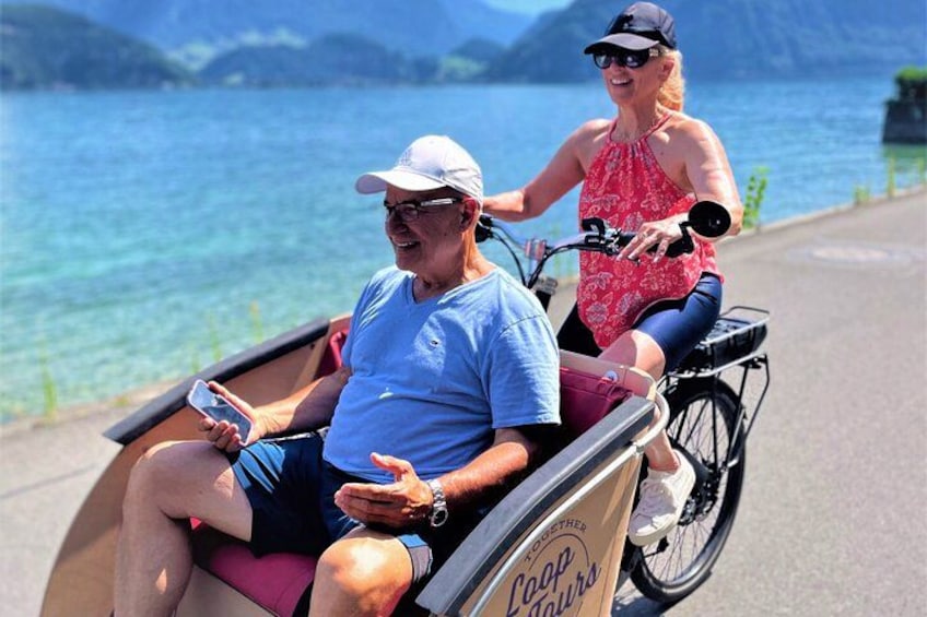 Un homme en fauteuil roulant et une femme à vélo, près d’un lac. 4