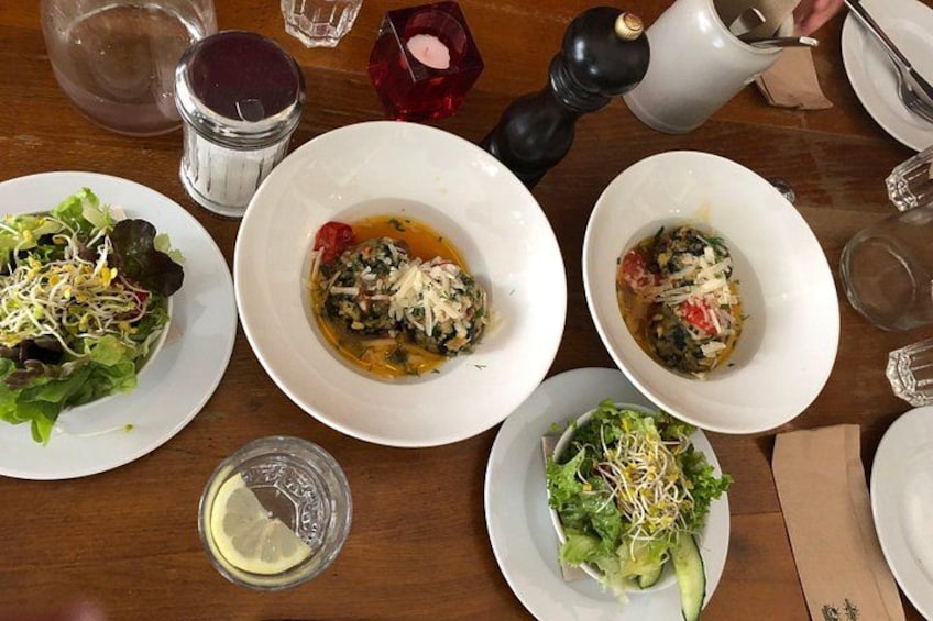A table with plates of food, including salads and dishes with cheese and tomato. 4