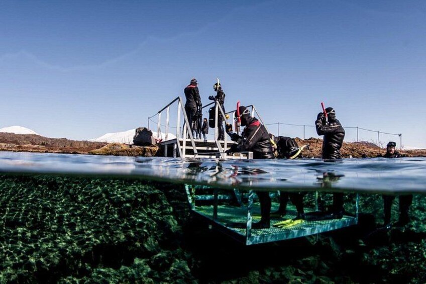 People in wetsuits on a boat, preparing for a dive. 2