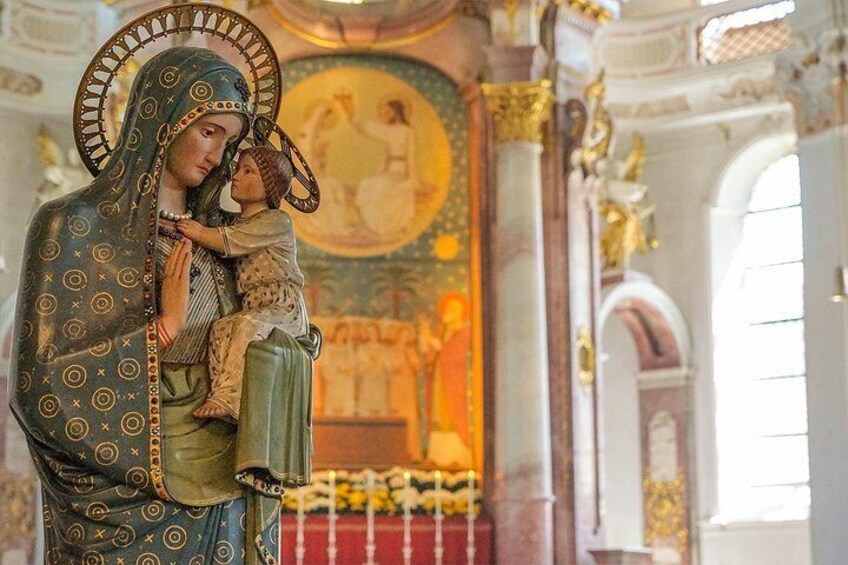 En religiøs statue af en kvinde, der holder et barn i en kirke. 1
