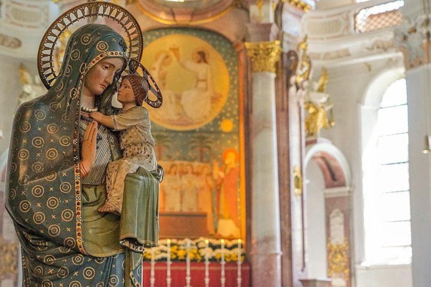 Una estatua religiosa de una mujer sosteniendo a un niño en el interior de una iglesia. 3