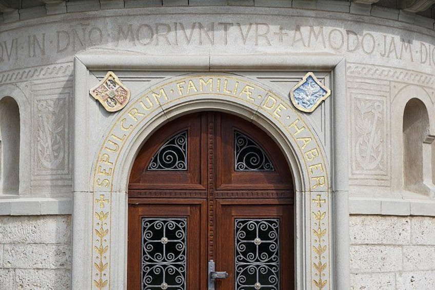 Una puerta de madera con detalles metálicos elaborados y un arco superior. 2