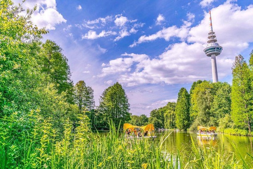 A lake with a tower in the background, surrounded by greenery. 5