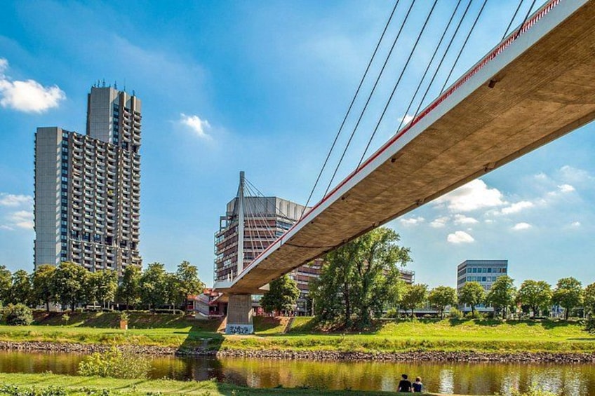 Un pont enjambant une rivière, avec des bâtiments et des arbres en arrière-plan. 4