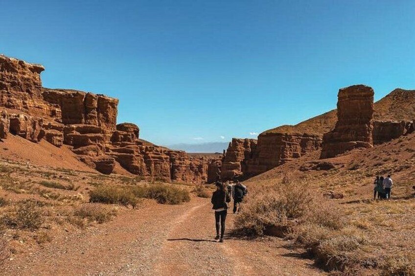 Un paisaje desértico con formaciones rocosas y un camino de tierra. 2
