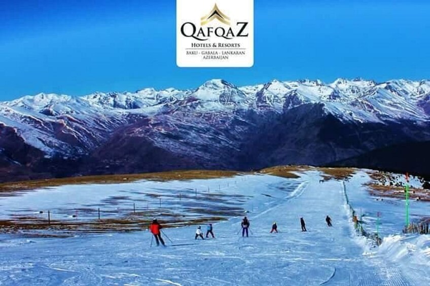 A snowy mountain landscape with skiers on a slope. 3