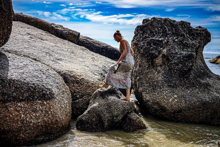 A person standing on a rock by a body of water. 3