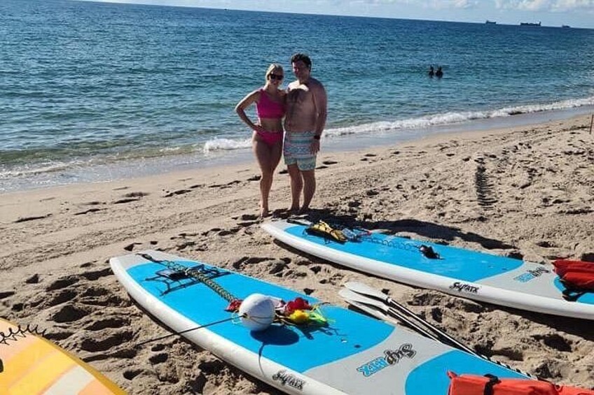 Una playa con tablas de surf y una pareja junto al agua. 1