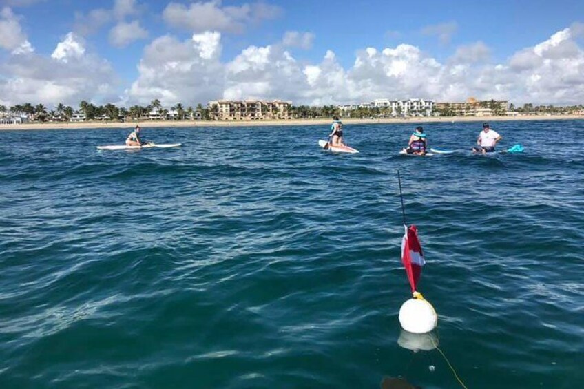 A group of people surfing on the ocean with a buoy in the foreground. 3