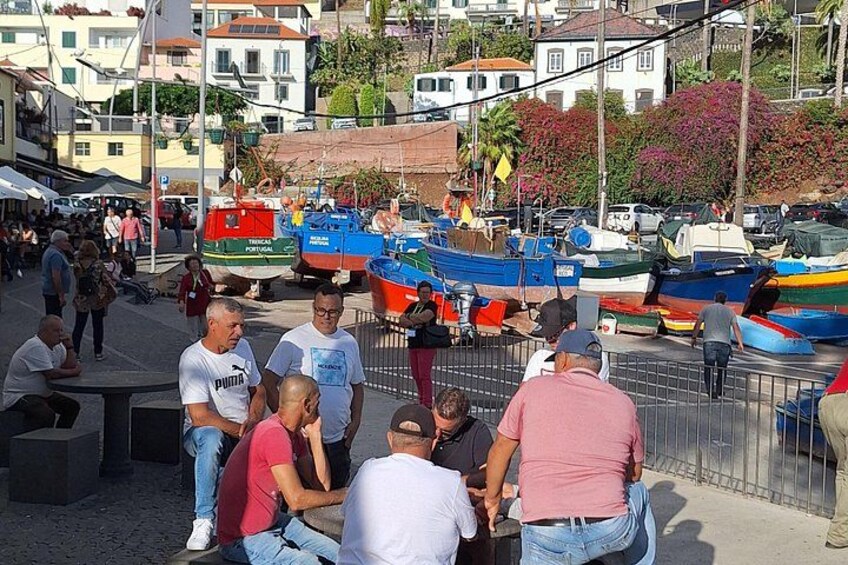 Un grupo de personas reunidas cerca de barcos, con un puerto deportivo y edificios al fondo. 2