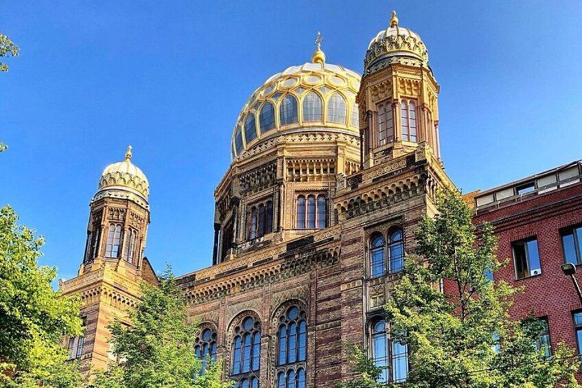 A historic building with ornate architecture, including a large dome and two smaller domes. 1