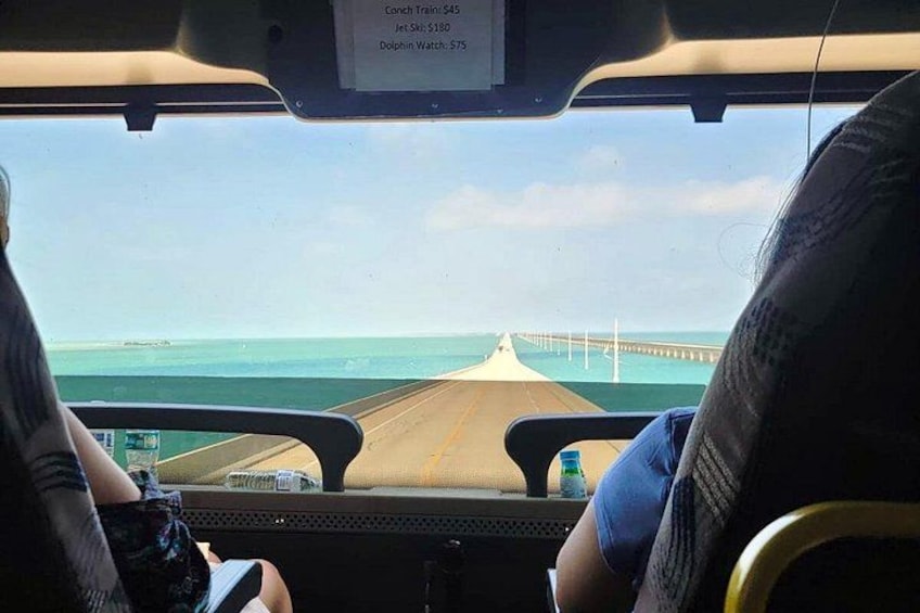 A view from inside a vehicle looking out to a bridge over water. 3