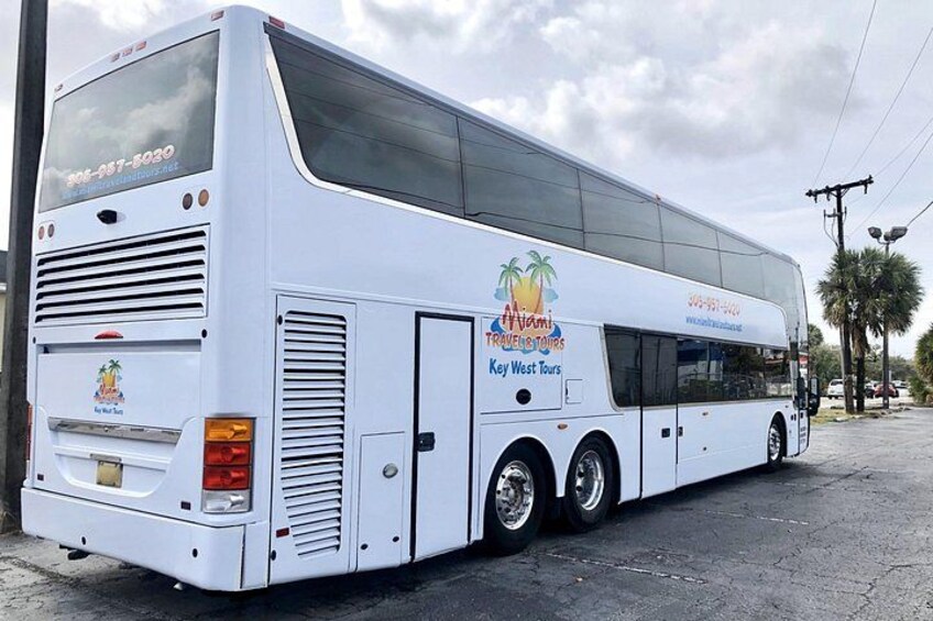 A white bus with Miami Travel Tours branding, parked on a street. 4