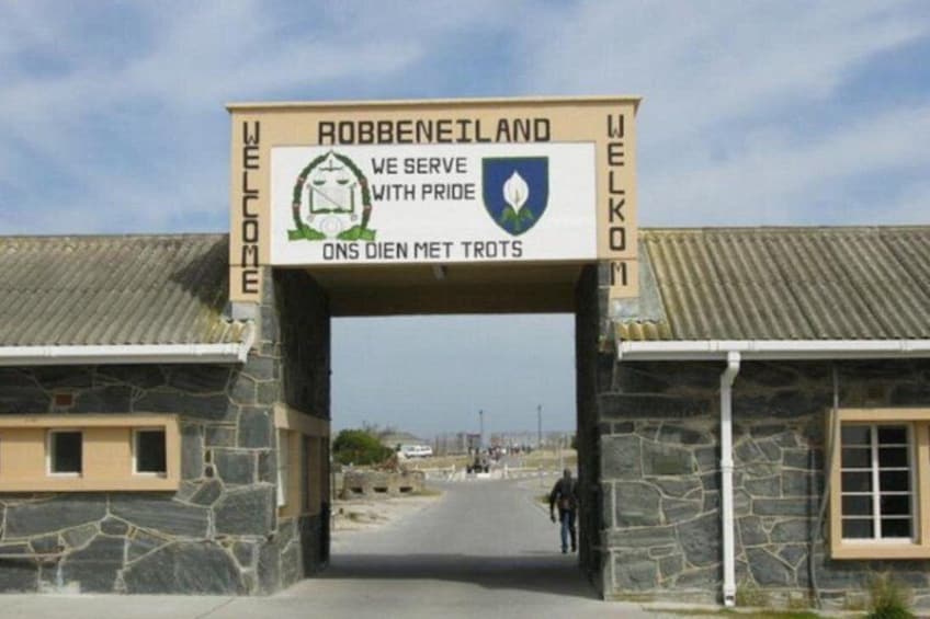 Une arche en pierre avec une pancarte d’accueil pour Robbeneiland, ornée d’un blason et d’un texte rédigé en plusieurs langues. 4