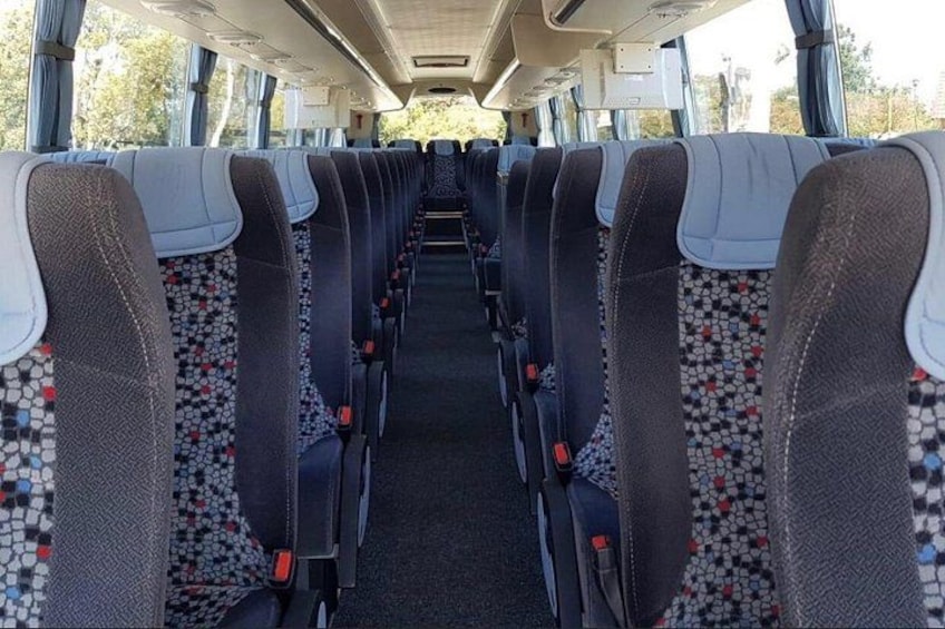 L'intérieur d'un autobus, avec des rangées de sièges, une allée centrale et des fenêtres sur les côtés. 5