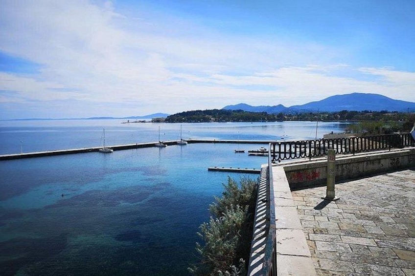 A clear blue body of water with a stone walkway and a railing. 3