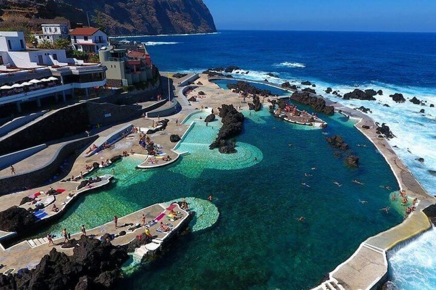 A coastal resort with multiple swimming pools and a rocky shoreline. 1