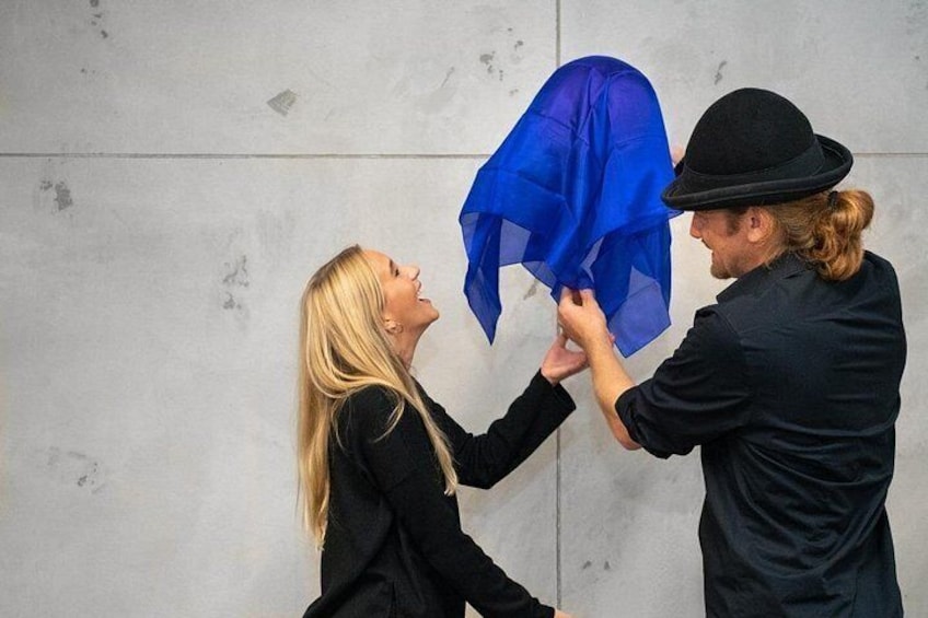 Twee personen houden een blauwe paraplu vast. 2