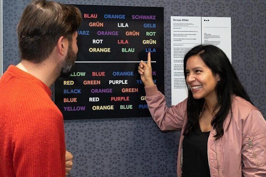 Twee personen die een kleurengecodeerd schema op een muur bekijken. 3