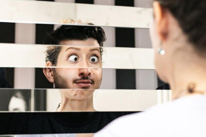 A person looking into a mirror with a checkered background. 4