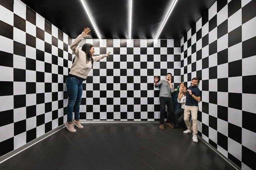 A room with black and white checkered walls and a group of people posing. 3